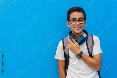 Pre-adolescent in front of a blue school wall