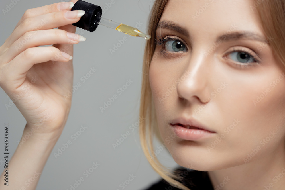 Concept skin care organic natural cosmetic product. Beauty Woman holding dropper around face oil for dark circles under eyes Concept skin care organic natural cosmetic product. Beauty Woman holding dropper around face oil for dark circles under eyes