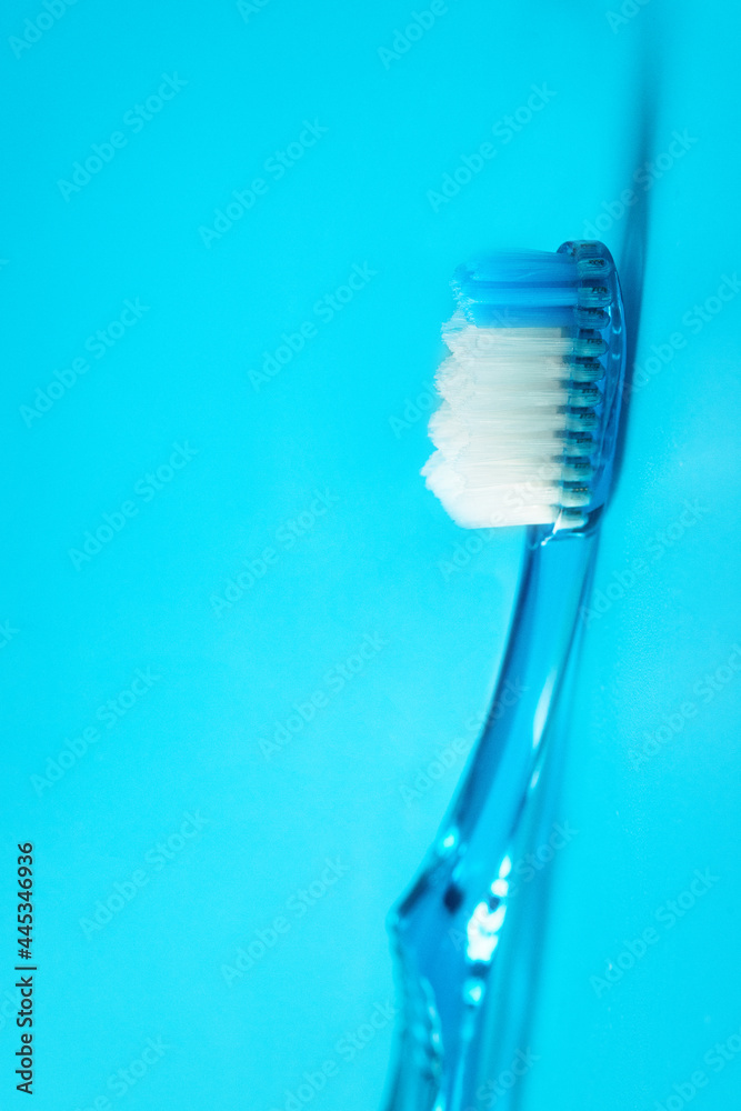 Blue toothbrush with shadow on blue baclground. Essential dental care for oral health concept.Copy space Blue toothbrush with shadow on blue baclground. Essential dental care for oral health concept.Copy space