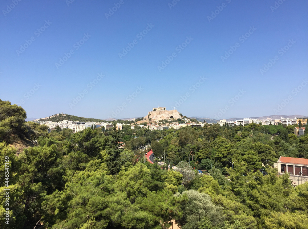 View of the Parthenon on the Athenian Acropolis and the Philopappos Monument on Mouseion Hill, seen from the tribunes of the Panathenaic Stadium or Kallimarmaro in Athens, Greece.