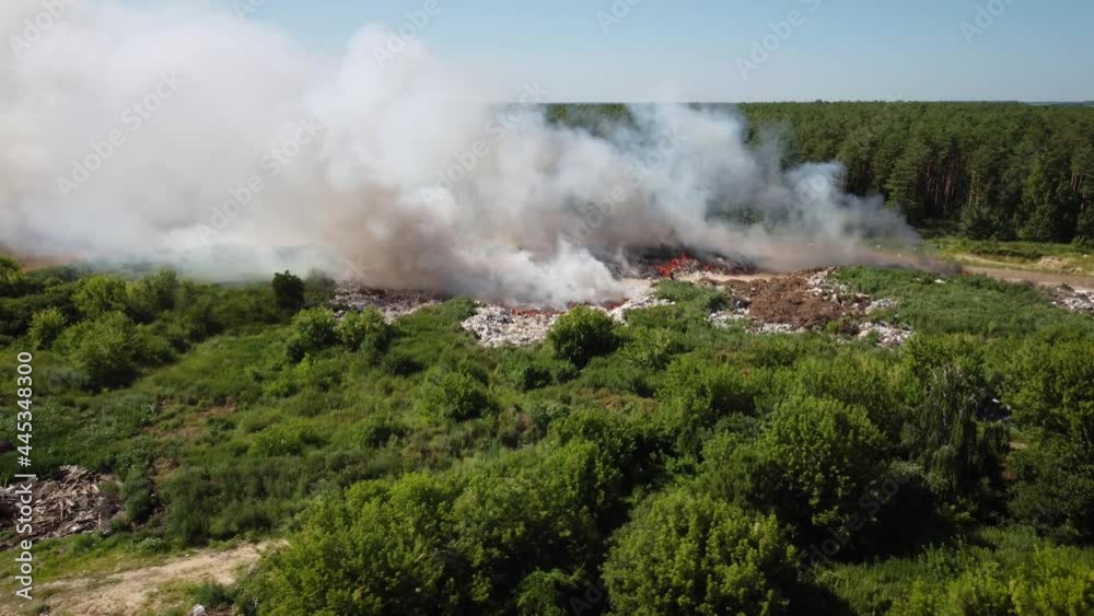 Flying over burning garbage dump. Environmental pollution caused by burning trash Flying over burning garbage dump. Environmental pollution caused by burning trash