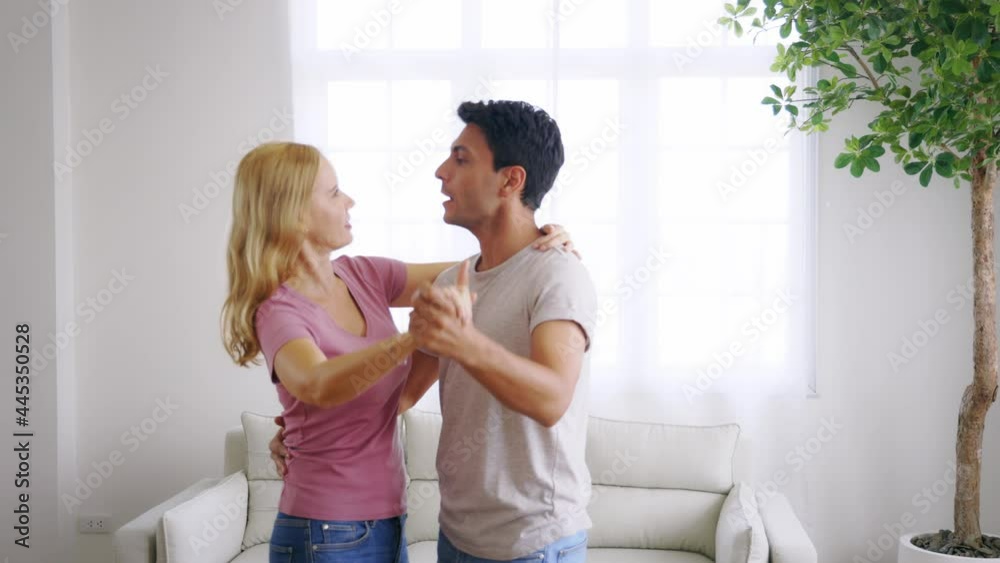 Young and handsome caucasian man and beautiful woman doing romantic couple in love dancing spending time together at home and feeling excited