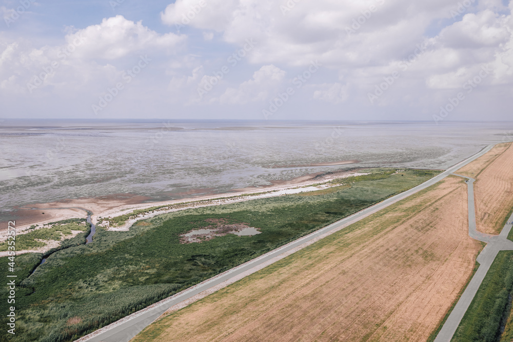 View from above on the dike and the Wadden Sea. Wadden Sea at low tide in the Netherlands or Germany 