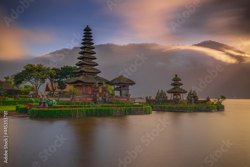 Pura Ulun Danu Bratan temple in Bali island. Beautiful balinese temple during sunrise. Balinese landmark. Cloudy sky. Water reflection. Slow shutter speed. Bratan lake  Bali