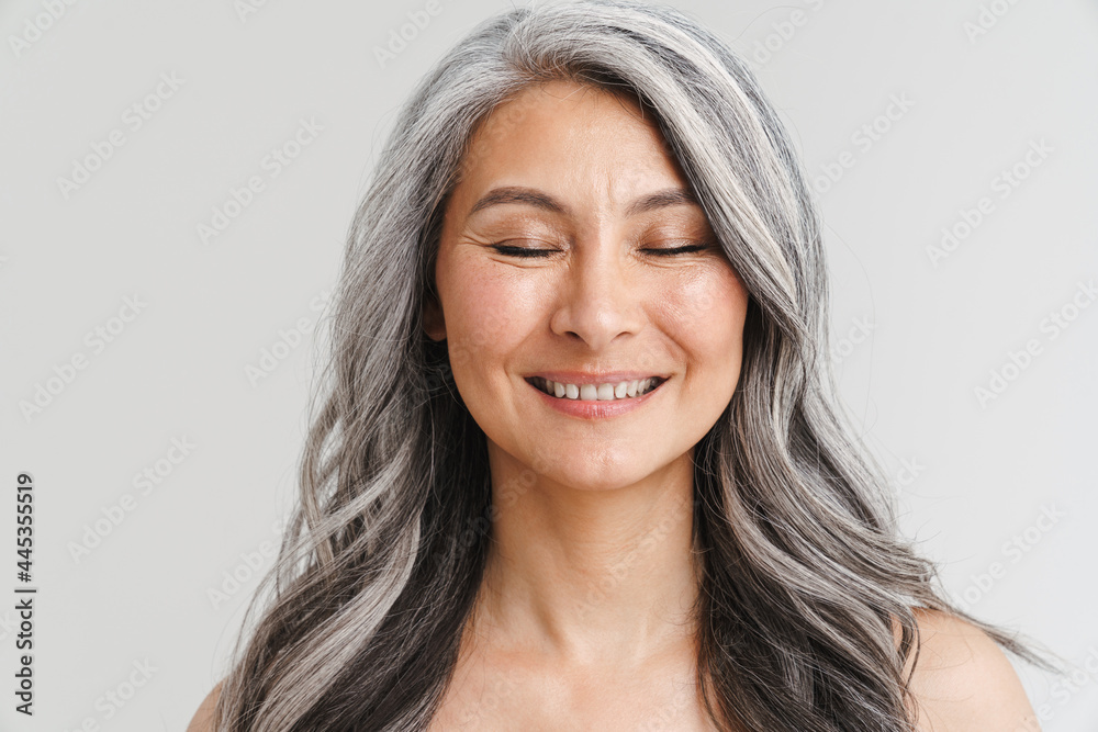 Fototapeta premium Mature shirtless woman with her eyes closed smiling at camera