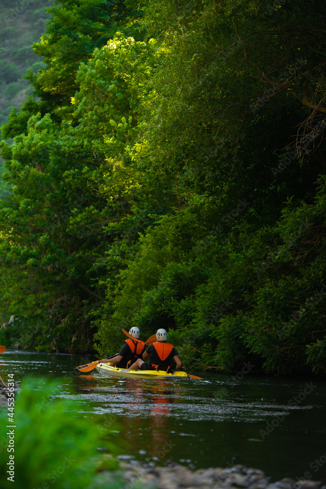 Two male friends kayaking together Two male friends kayaking together