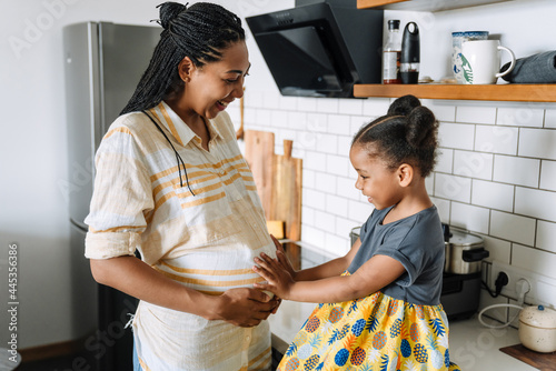 Wallpaper Mural Black girl touching her pregnant mother's belly in kitchen Torontodigital.ca