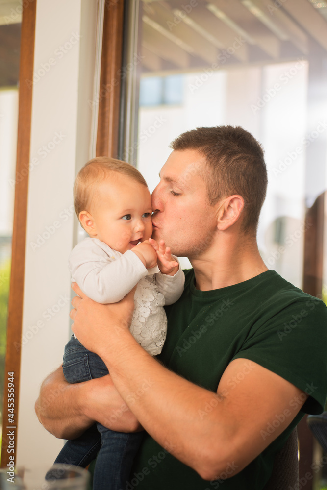 Father holding and kissing his baby