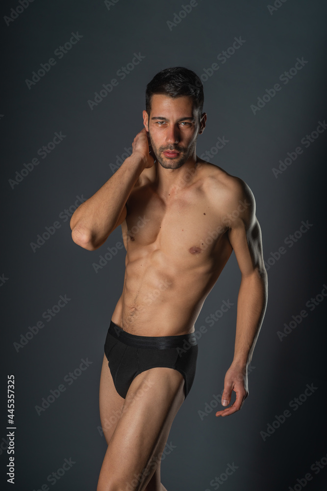 Fashion close-up portrait of a handsome male with bare torso posing in black underwear on isolated background Fashion close-up portrait of a handsome male with bare torso posing in black underwear on isolated background