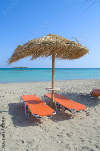 Group of sun loungers on the sandy beach. photo