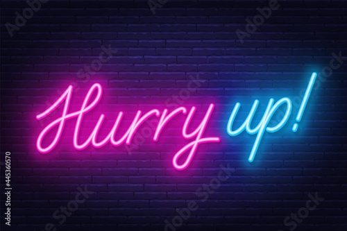 Neon sign hurry up on brick wall background.