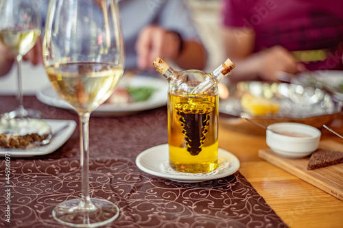 Glass on a high thin leg with white wine on the table in a restaurant