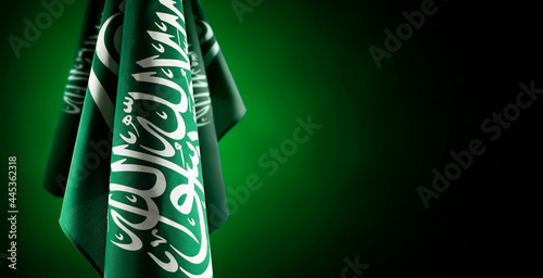 Saudi Arabia flags on left side with a dark green background, use it for national day and country national occasions photo