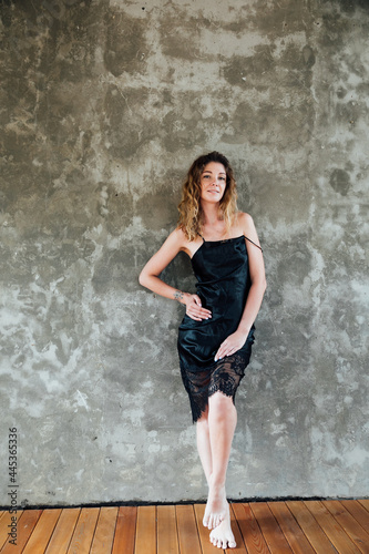 portrait of a beautiful woman in a black dress on a gray background