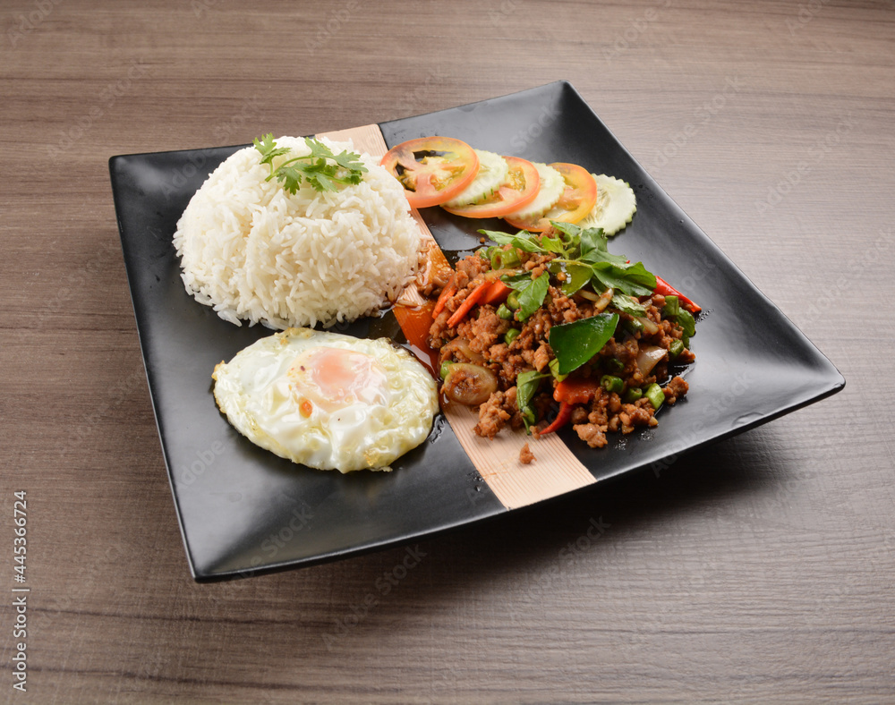 stir fried minced chicken meat in spicy chilli sauce with white rice and fried egg on wood background asian halal set lunch menu stir fried minced chicken meat in spicy chilli sauce with white rice and fried egg on wood background asian halal set lunch menu