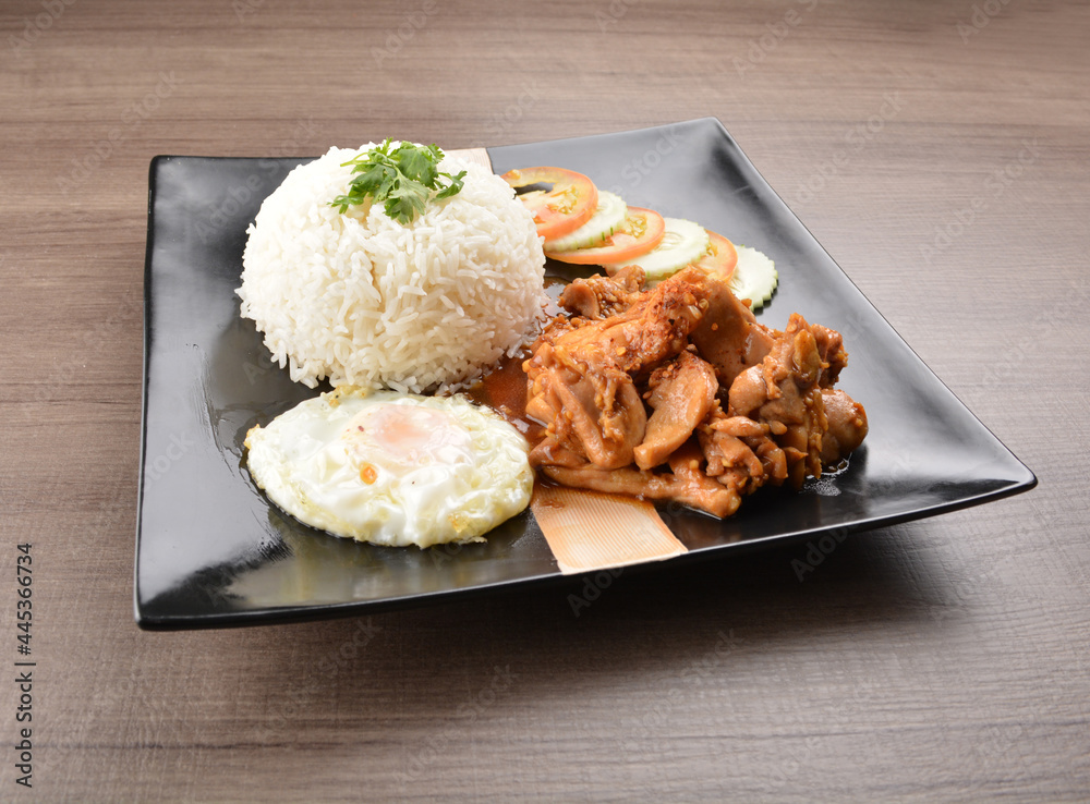 stir fried chicken meat in garlic soy sauce with white rice and fried egg on wood background asian halal set lunch menu stir fried chicken meat in garlic soy sauce with white rice and fried egg on wood background asian halal set lunch menu