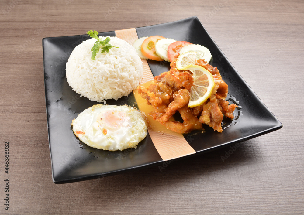 stir fried chicken meat in lemon sour sauce with white rice and fried egg on wood background asian halal set lunch menu stir fried chicken meat in lemon sour sauce with white rice and fried egg on wood background asian halal set lunch menu
