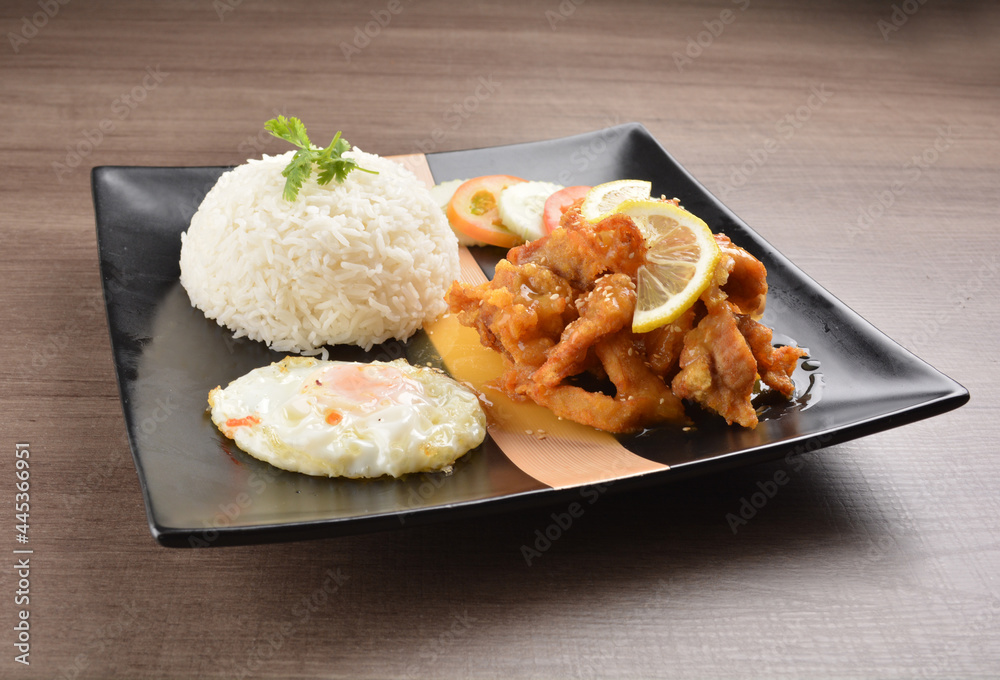 stir fried chicken meat in lemon sour sauce with white rice and fried egg on wood background asian halal set lunch menu stir fried chicken meat in lemon sour sauce with white rice and fried egg on wood background asian halal set lunch menu