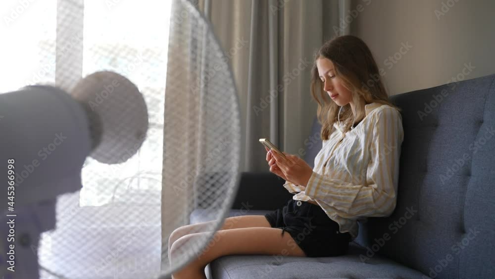 Teenager with the phone in front of cooling fan.