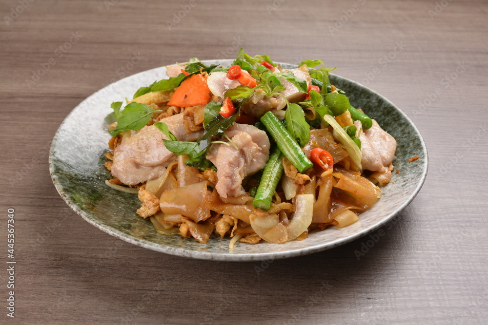 wok fried noodle phad Thai with chicken meat on wood background asian halal set lunch menu