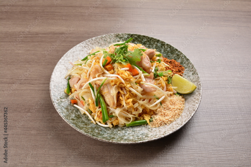 wok fried noodle phad Thai with chicken meat on wood background asian halal set lunch menu