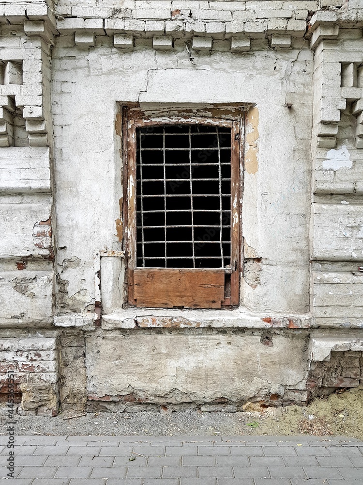 Old window with iron bars in a stone house