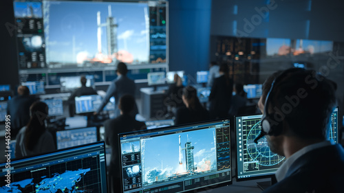 Space Flight Dispatcher in Mission Control Center Witness Successful Space Rocket Launch. Flight Control Employees Sit in Front Computer Displays and Monitor the Crewed Mission.