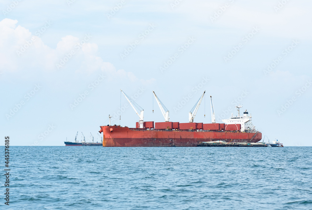 Large ship red color with big crane in the ocean landscape,Industrial boat in the sea logistic concept
