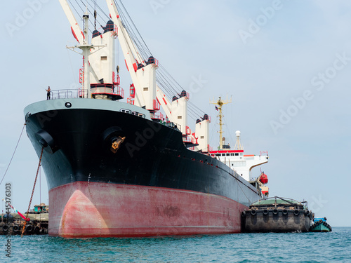 Large industrial ship with big crane in the ocean and blue sky,Cargo ship concept in the sea