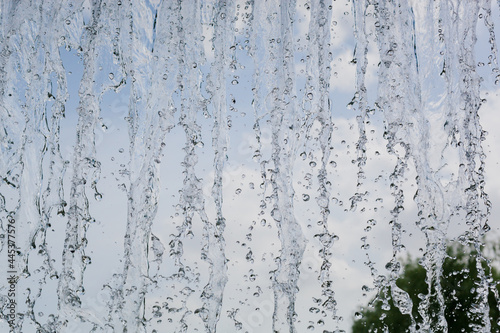 inside view of the falling water of the waterfall against the blue sky. water in motion © Vladimir Zlotnik