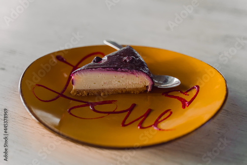 A piece of cake on a plate on a table in a cafe. Delicious vegetarian dessert in a cafe in Bali. Blueberry cheesecake vegan