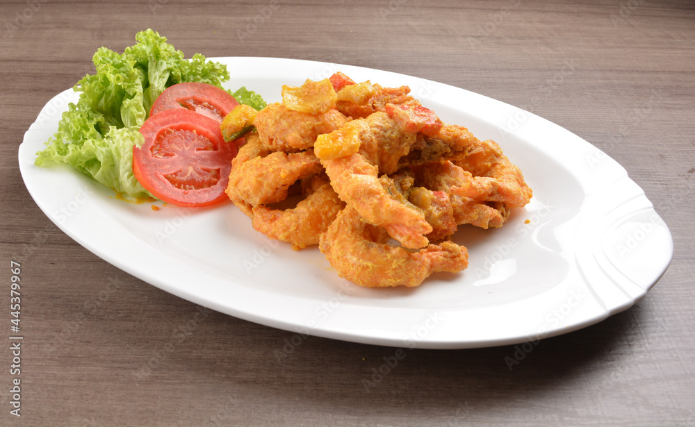 wok fried tiger prawn in salted egg yolk curry paste sauce on wood table asian halal menu wok fried tiger prawn in salted egg yolk curry paste sauce on wood table asian halal menu