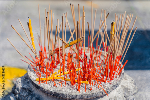 incense stick and yellow candle in green pot Buddhist always pray with incense in the temple and put them in sand pot . Lighting incense in the temple