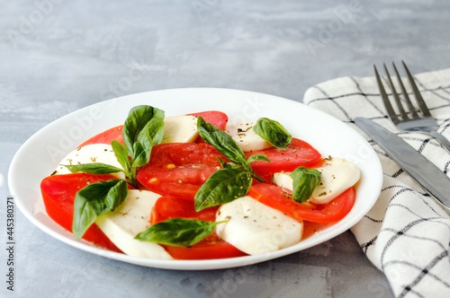 Close-Up Of Cheese And Tomatoes With Basil Leaves In Plate.
