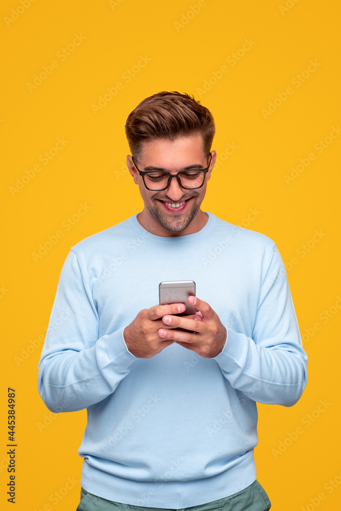 Optimistic young guy using smartphone Optimistic young guy using smartphone