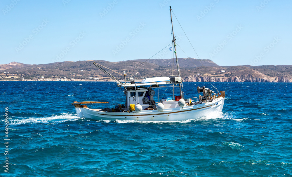Fishing boat moving in wavy sea. Cyclades Greece
