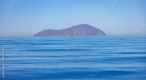 Greece. Aegean sea. Blue sky, land and calm sea water background