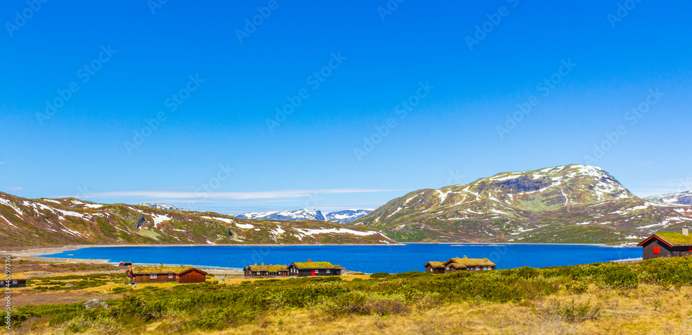 Vavatn lake panorama landscape cottages huts snowy mountains Hemsedal Norway.