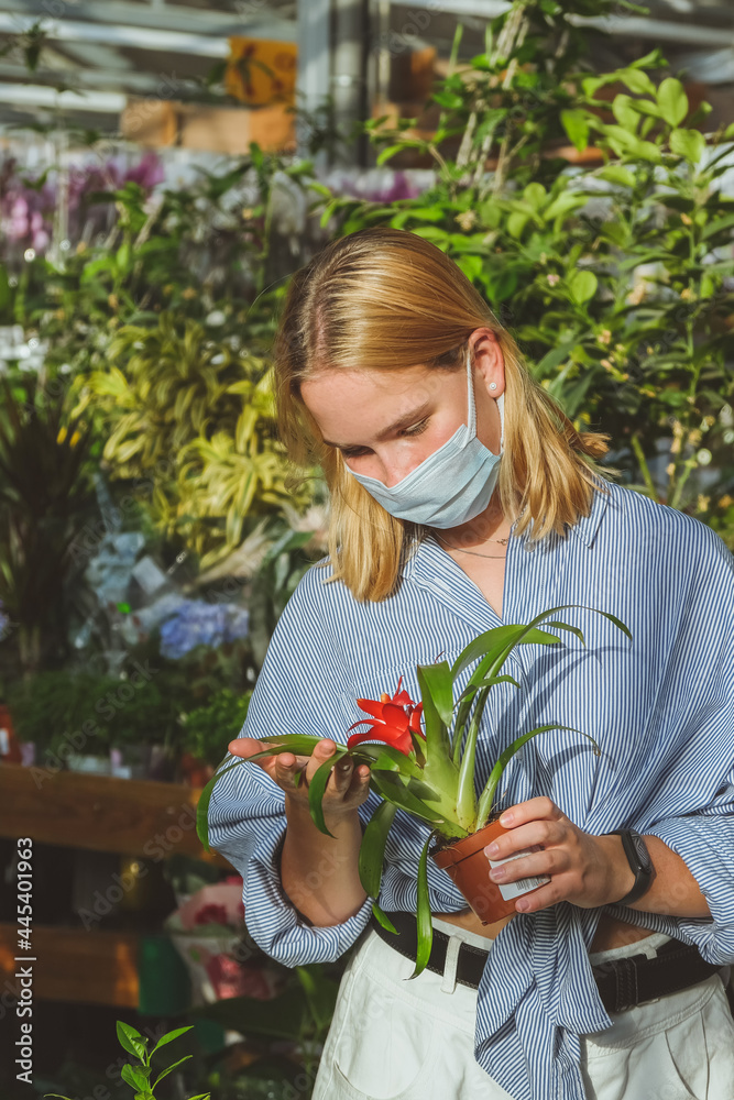 Obraz premium shopping in plant gardening shop mask girl pick flowers for garden shopping real, home gardening, eco, eco friendly,Our Life Offline.