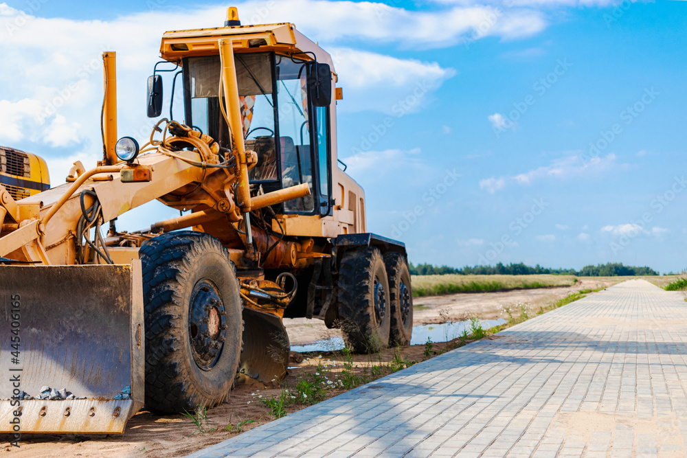 Road grader - heavy equipment for road construction and earthworks. Leveling and improvement of the ground surface. Construction of roads and transport communications. Road grader - heavy equipment for road construction and earthworks. Leveling and improvement of the ground surface. Construction of roads and transport communications.