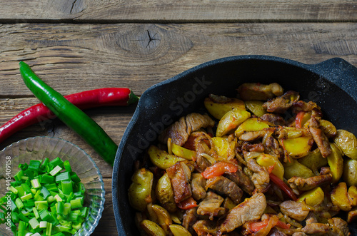 Georgian ojahuri or roasted potato with meat and vegetables on wooden background