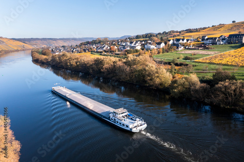 Germany, Rhineland-Palatinate, Helicopter view of barge sailing along Moselle river with village in background photo