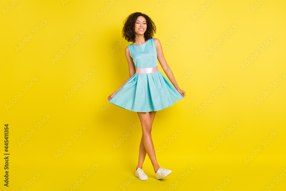 Full size photo of nice wavy hairdo young lady wear blue dress sneakers isolated on yellow color background Full size photo of nice wavy hairdo young lady wear blue dress sneakers isolated on yellow color background