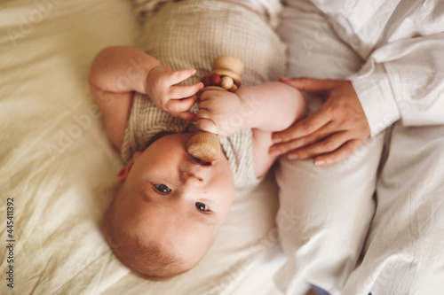 European Baby 3 4 months old with rattle wooden toy, top view photo