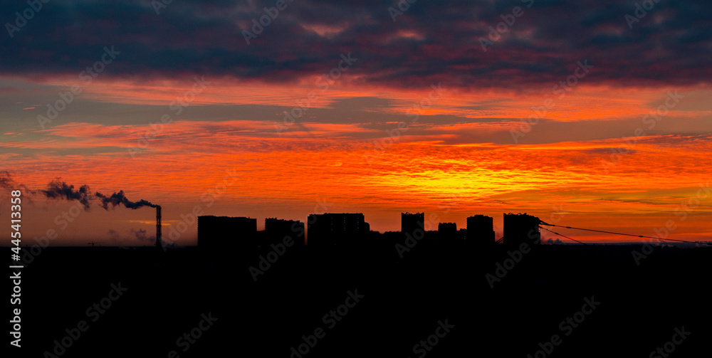Orange beautiful sunset over the dark city