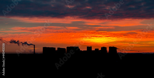 Orange beautiful sunset over the dark city © Denius