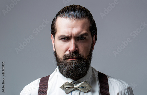 Canvastavla Portrait of handsome bearded man in white shirt and bow tie, suspenders