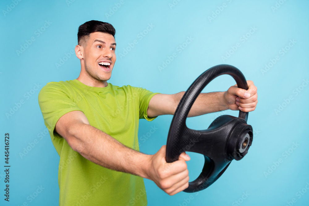 Photo portrait man in green t-shirt driving car first time passed test isolated pastel blue color background Photo portrait man in green t-shirt driving car first time passed test isolated pastel blue color background