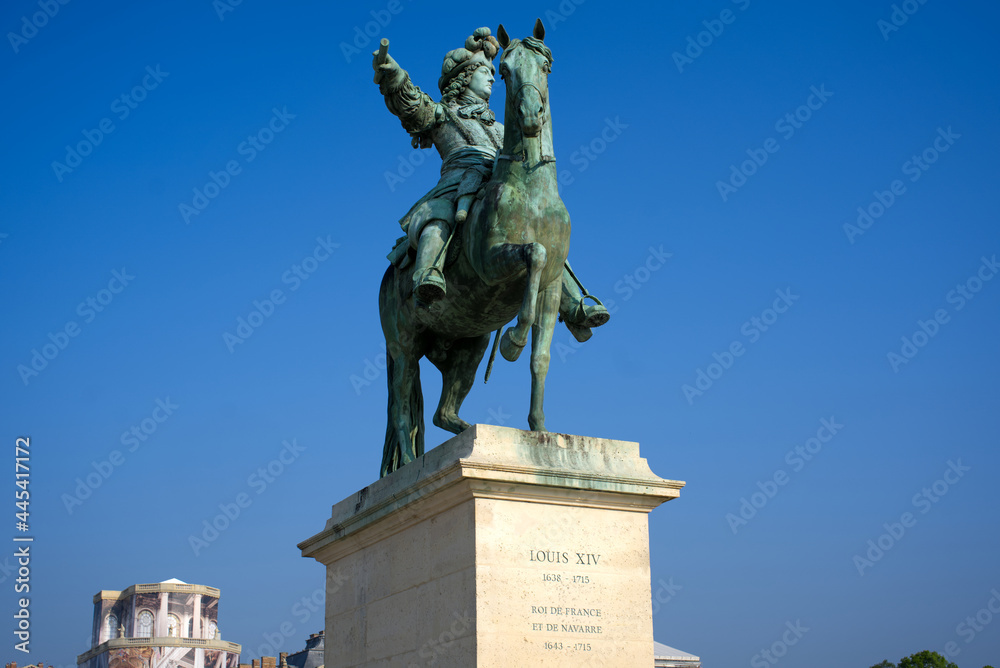 Bronze statue of historic king of France Louis XIV at in front of Palace of Versailles on a sunny spring day. Photo taken April 30th, 2019, Paris, France.