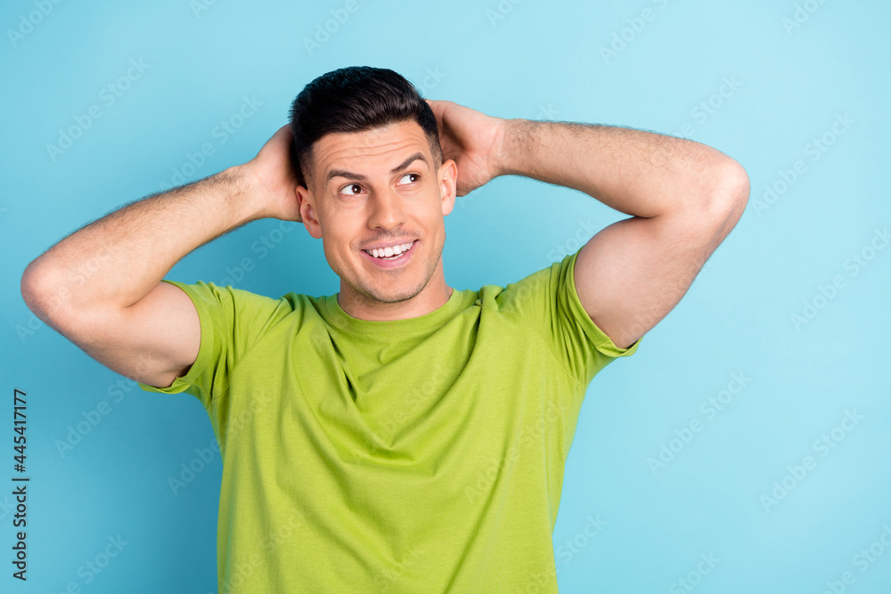 Photo of happy positive young man look empty space hold hands hair smile imagine isolated on blue color background Photo of happy positive young man look empty space hold hands hair smile imagine isolated on blue color background
